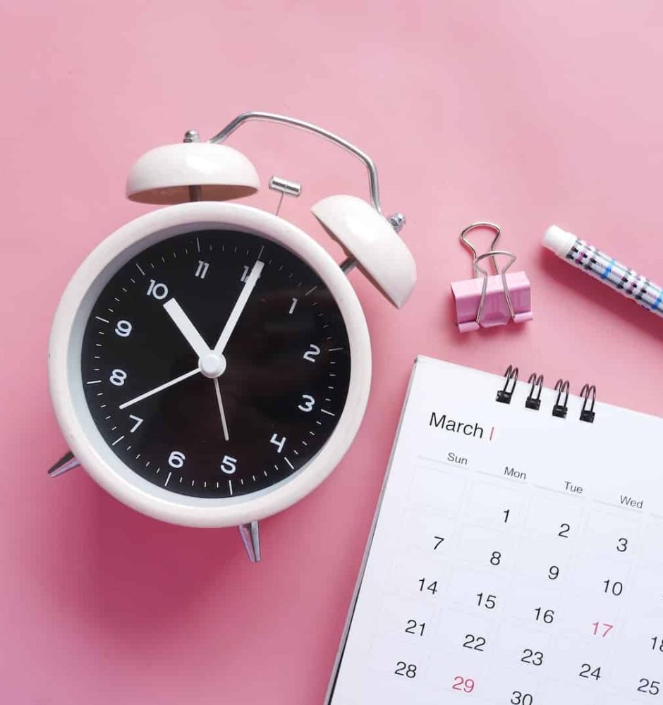 white and pink analog alarm clock